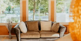 Photo du hall d'entrée, un canapé en cuir marron, à l'hôtel Iroko, Aix les Bains.
